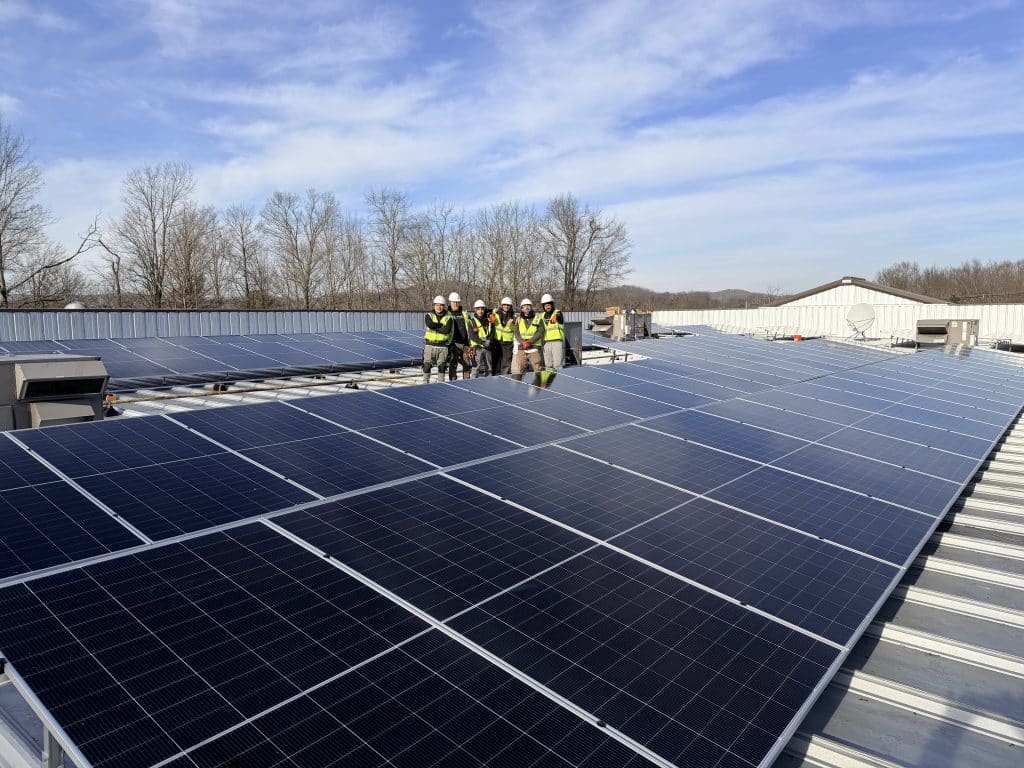 Infinity Energy install crew on a commercial solar project — six team members in safety gear